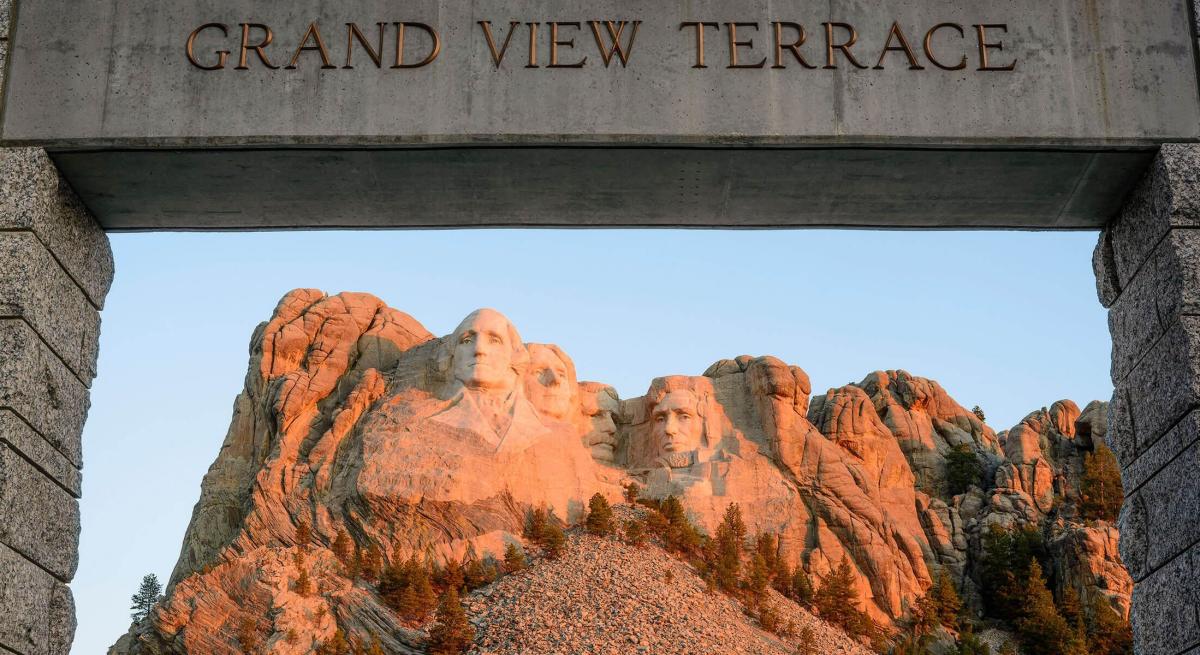Early morning light on the faces of Mount Rushmore with the Grand View Terrace sign