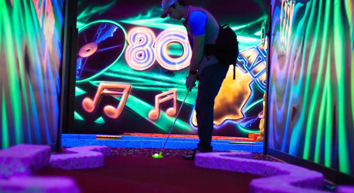 black light mini golf course with retro art in the background in rapid city sd