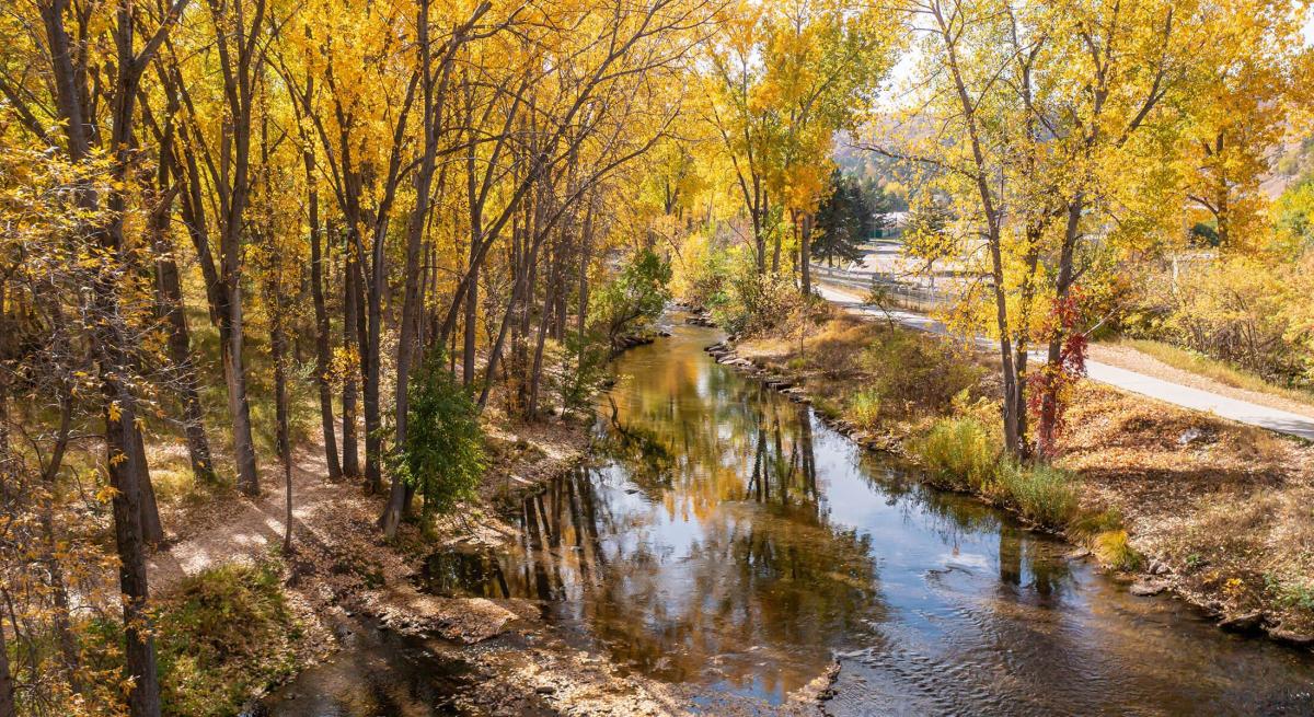 Fall colors surround Rapid Creek near Canyon Lake Park in Rapid City, Sd