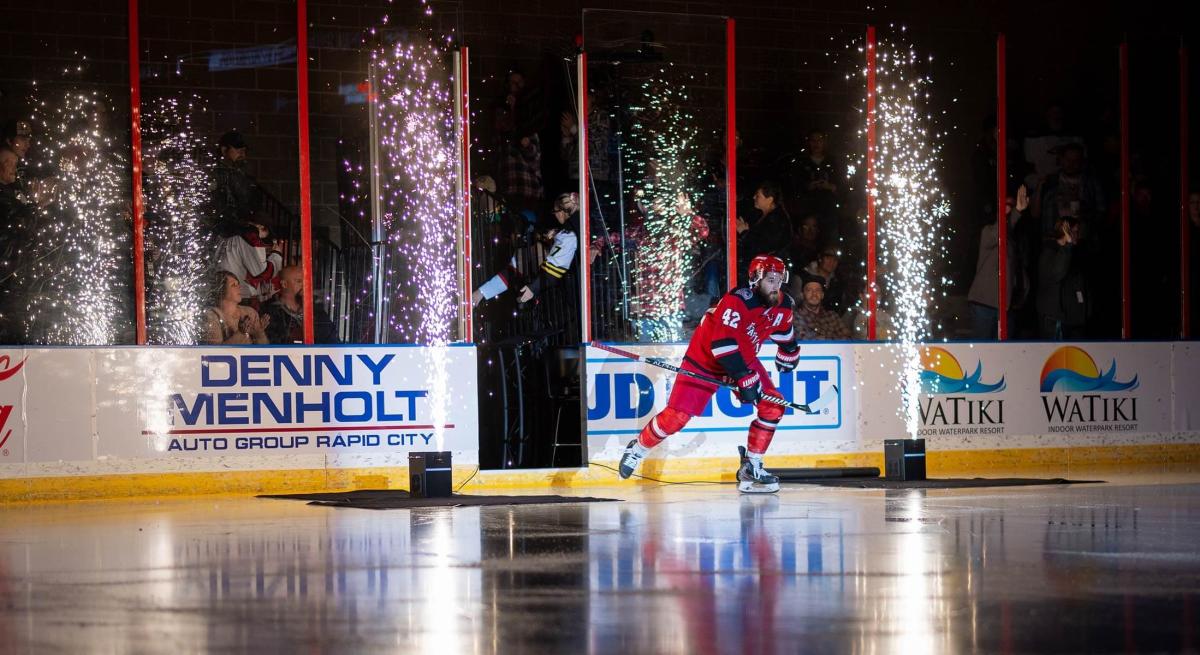 Rush hockey player coming onto the ice with fireworks going