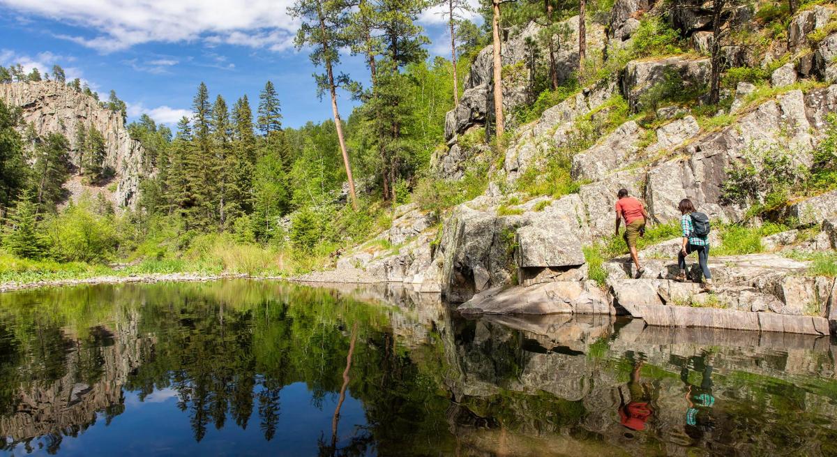 hikers exploring the shoreline of sheridan lake in the black hills of south dakota