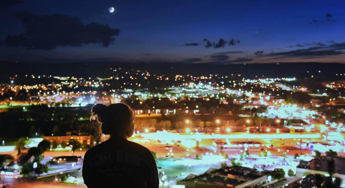 Visitor taking in the city lights at night from on top of skyline drive in rapid city, south dakota
