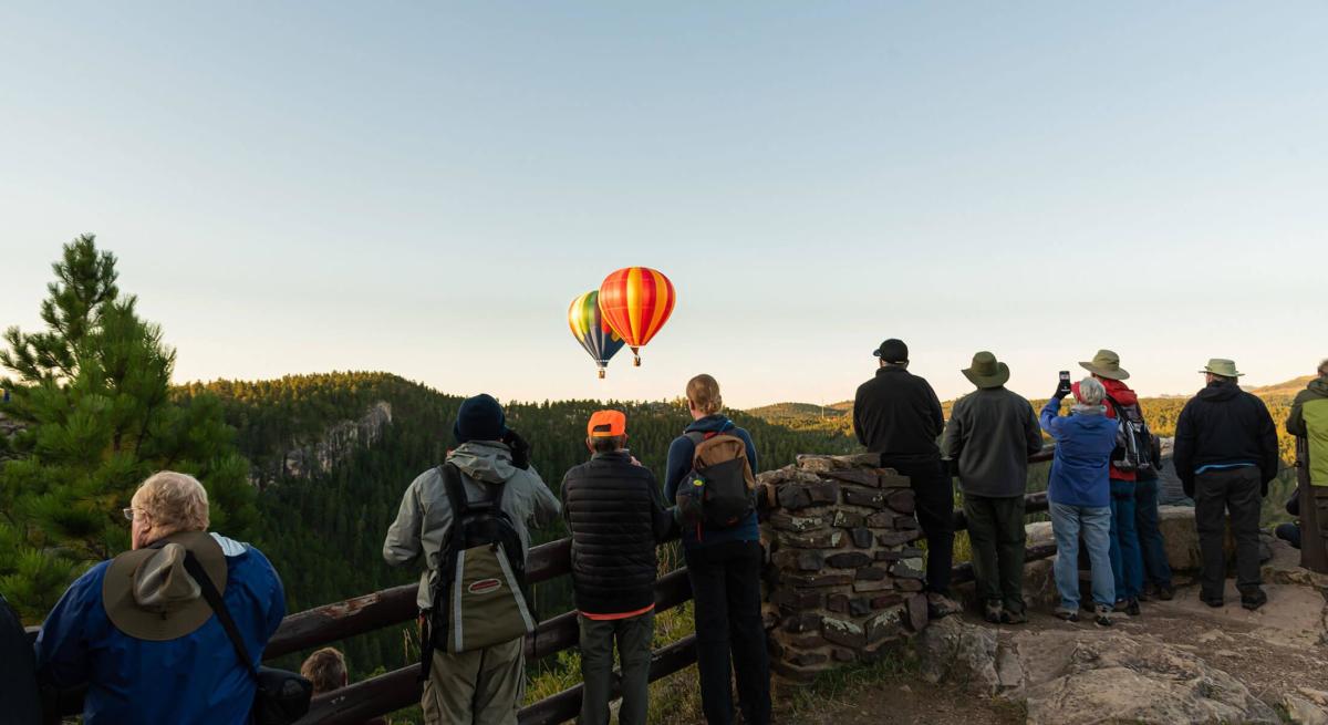 Hot Air balloons rising from the Stratobowl with spectators watching in the Black Hills National Forest