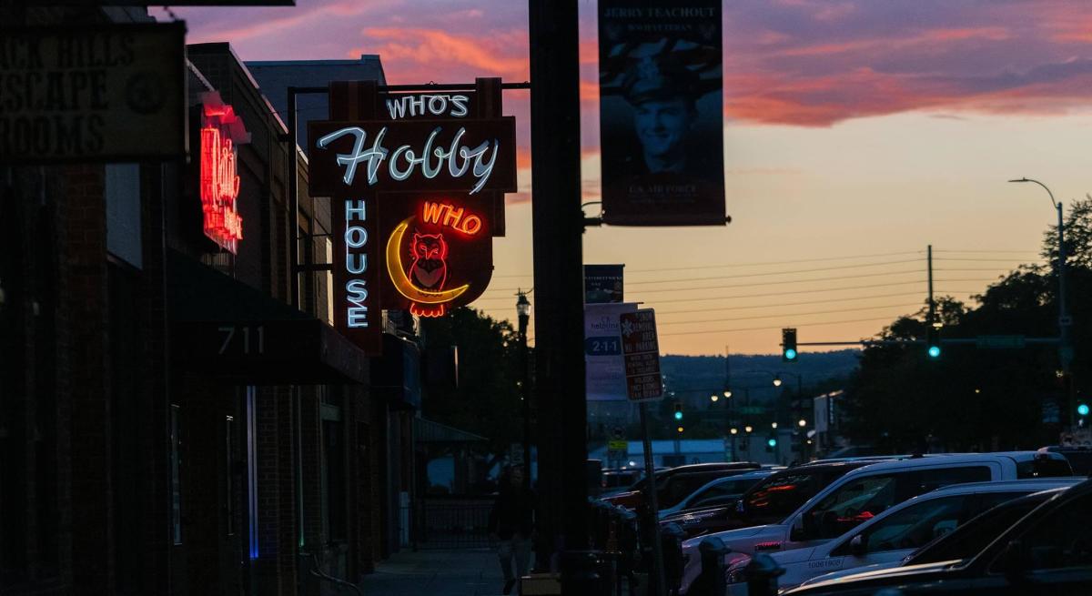 Sunset behind the neon sign of rapid city's who's hobby house 