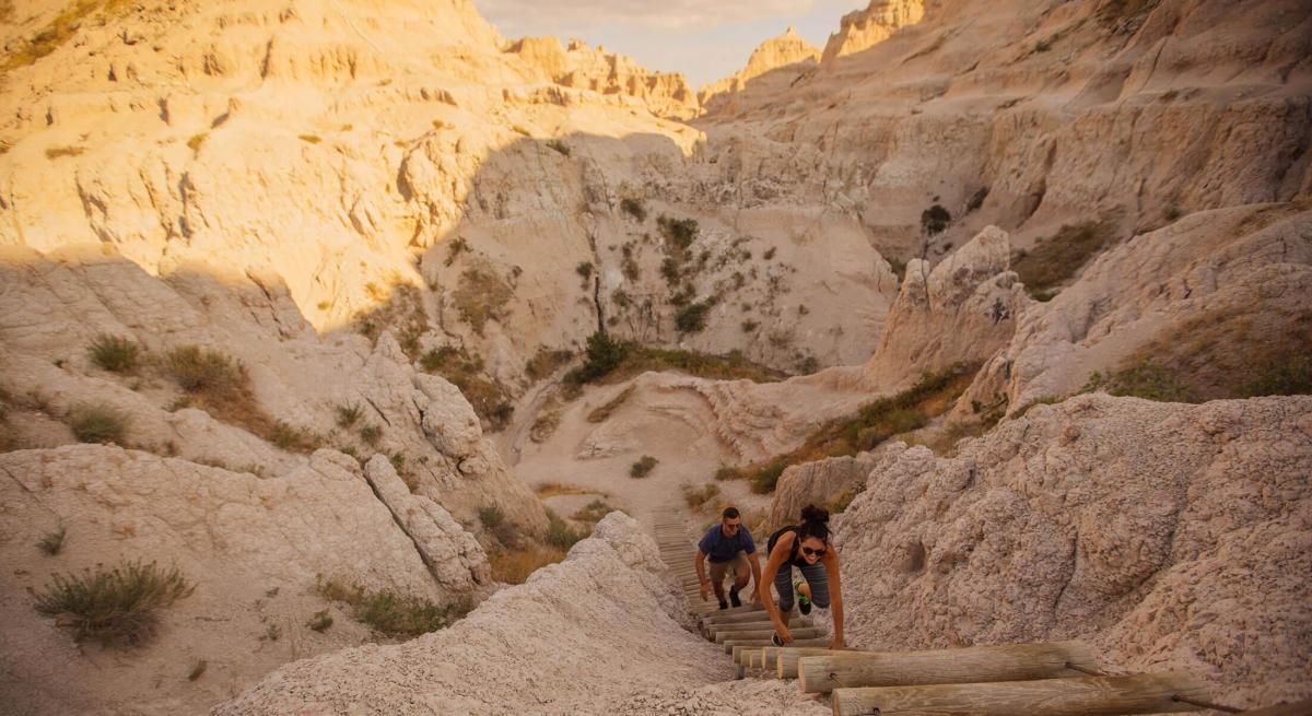 Hikers climbing the ladder at Notch Trail in Badlands National Park
