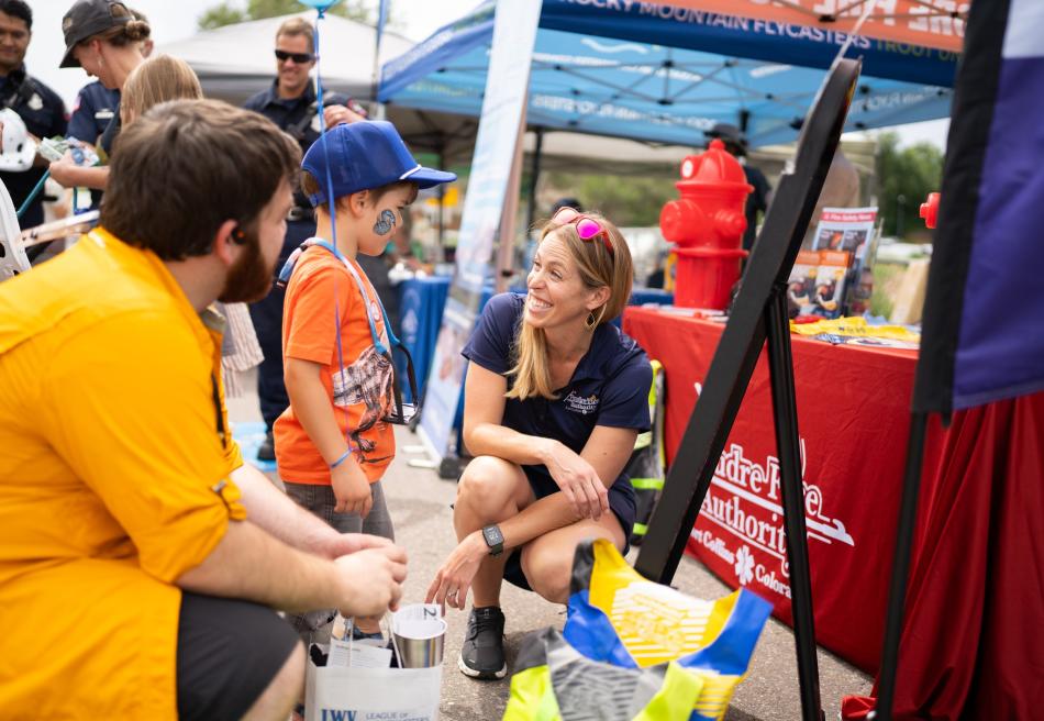 Child with Dad talks to worker at Poudre Fire Authority