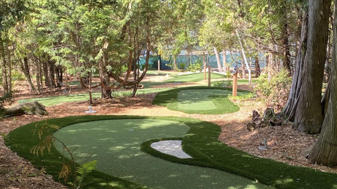 The golf course at Mega Pines Mini golf features pine trees around the edges