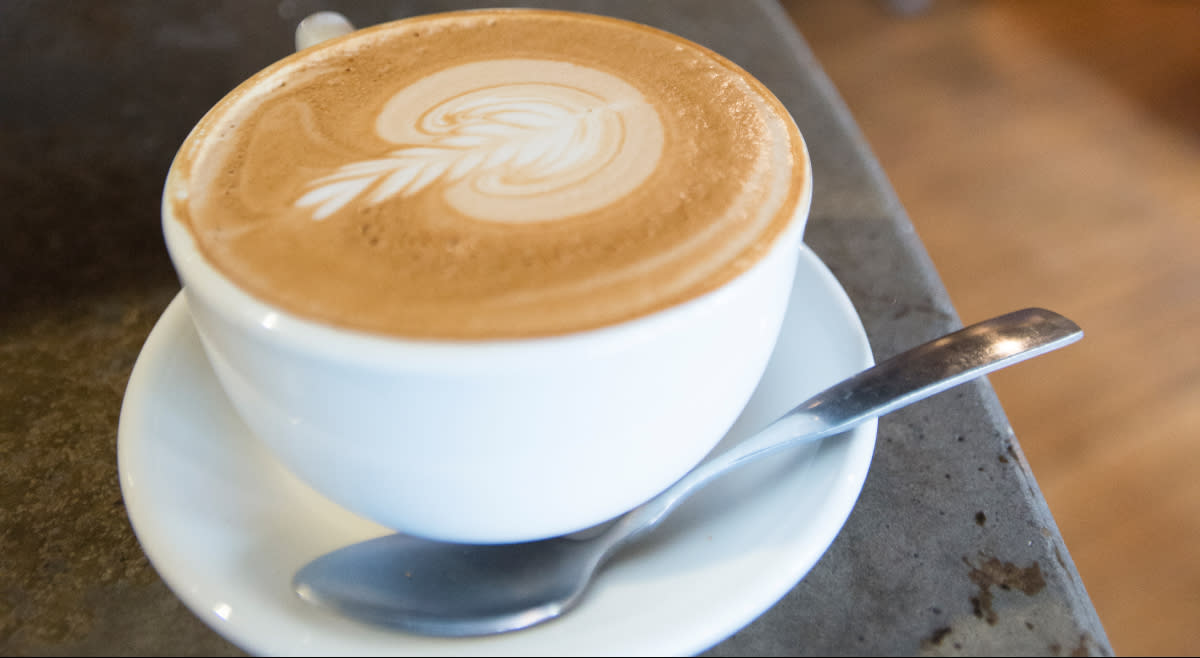 Hot coffee beverage with a design on top at Nola Coffee