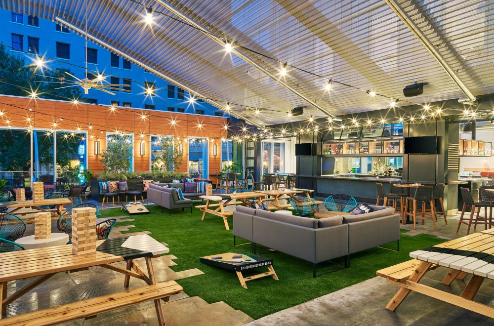 Aloft Austin's rooftop patio bar complete with turf, picnic tables, lounge sets, patio games and a view of the downtown skyline