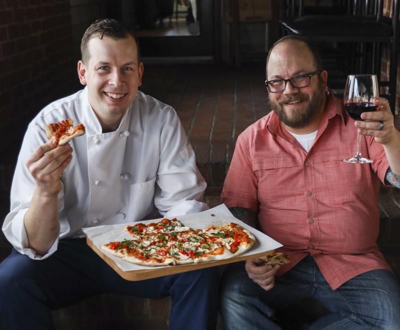 Owners of Vin 909 with pizza and wine