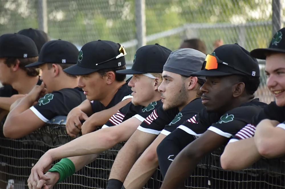 The Clayton Clovers Baseball players at dugout fence.
