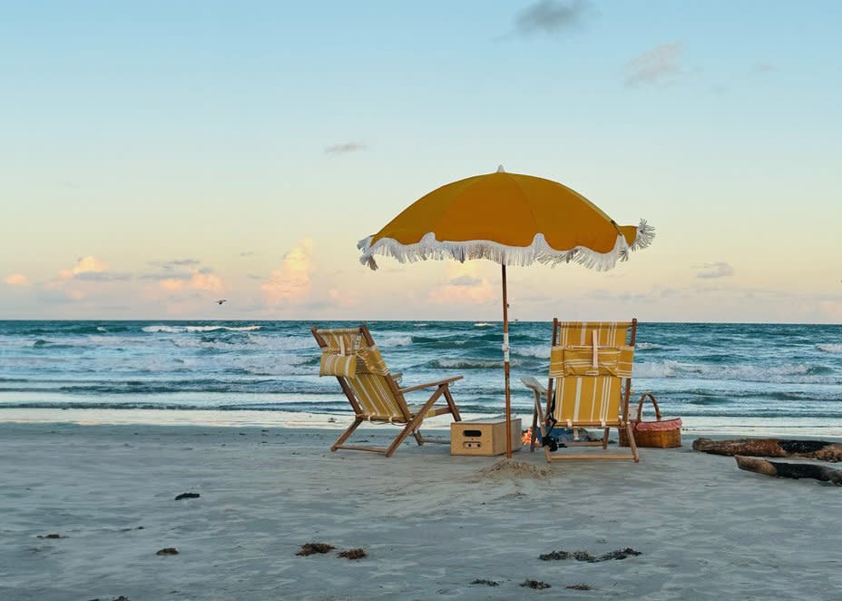 Winter beach with two yellow chairs and an umbrella