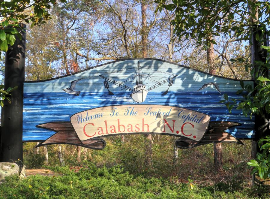 a wooden sign welcoming visitors to Calabash, NC the "Seafood Capital"