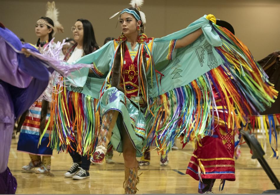 A native American girl in traditional ware dancing
