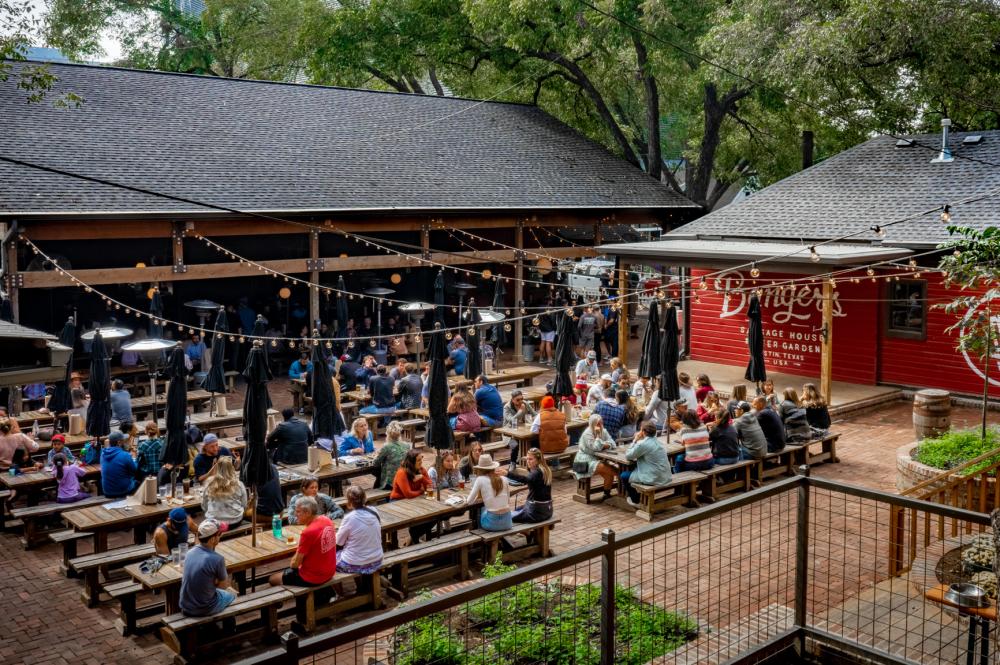 The patio at Banger's with people sitting at picnic tables eating and drinking.