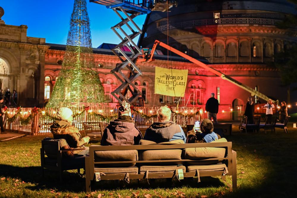 Visitors on a couch watching the glass tree being built