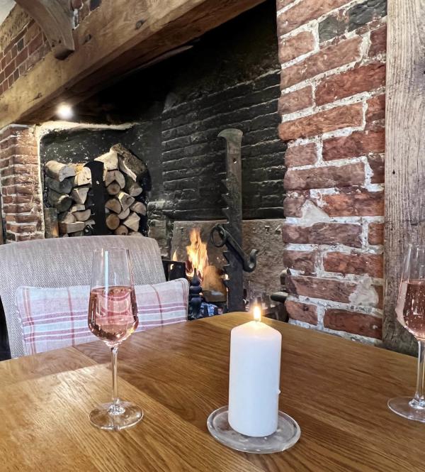 A glass of champagne by the fire at The Angel Inn, Petworth