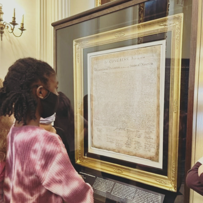 A black female student studies the Declaration of Independence at the Founding Freedoms Exhibit