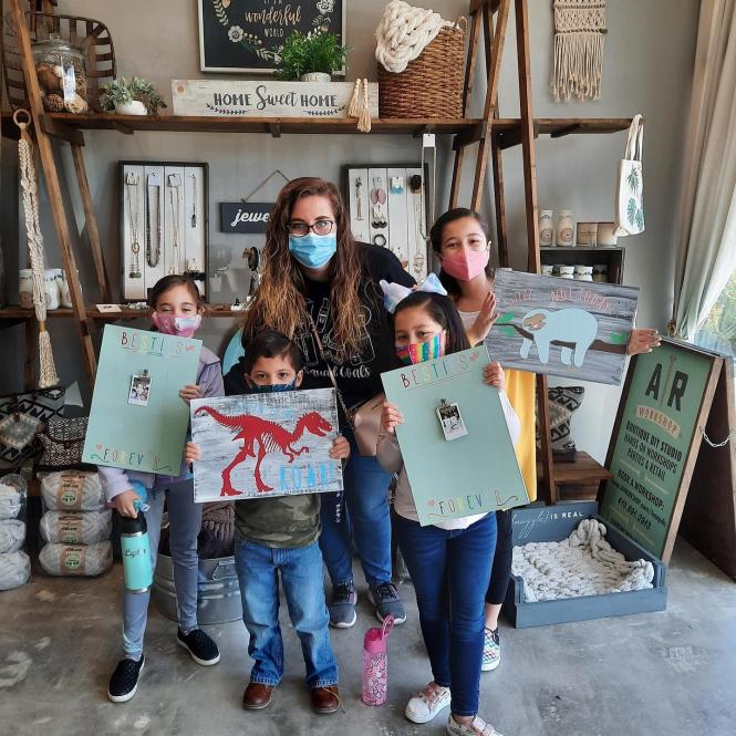 A group of kids show off their art work at AR Workshop.