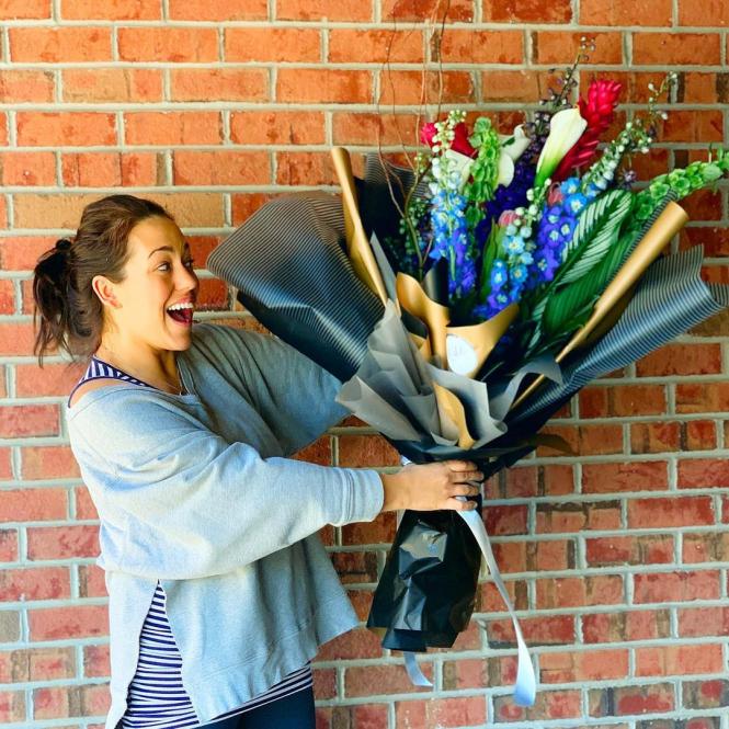 A happy girl with a large bouquet of flowers.