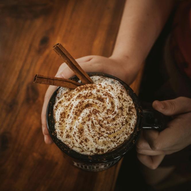 Rise up Coffee latte with whipped cream and cinnamon