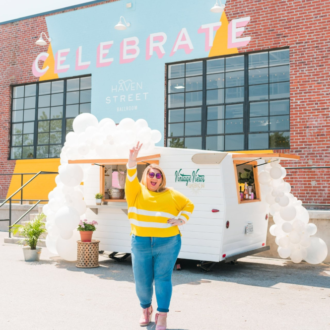 Girl stand in front of mobile cocktail bar and balloons