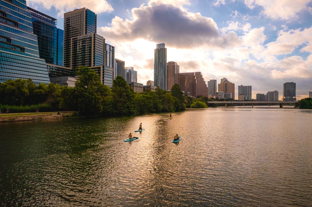 People stand up paddleboarding on Lady Bird Lake.