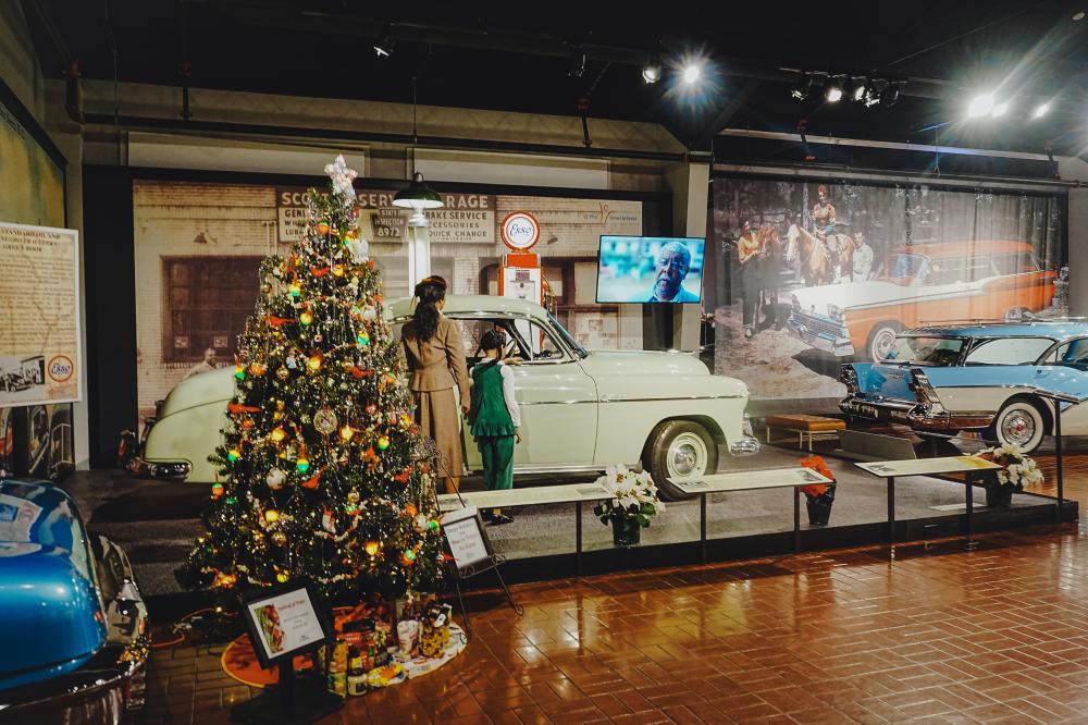 A Christmas Tree is set up in front of a historic car during the Winter Wonderland at the Gilmore Car Museum.