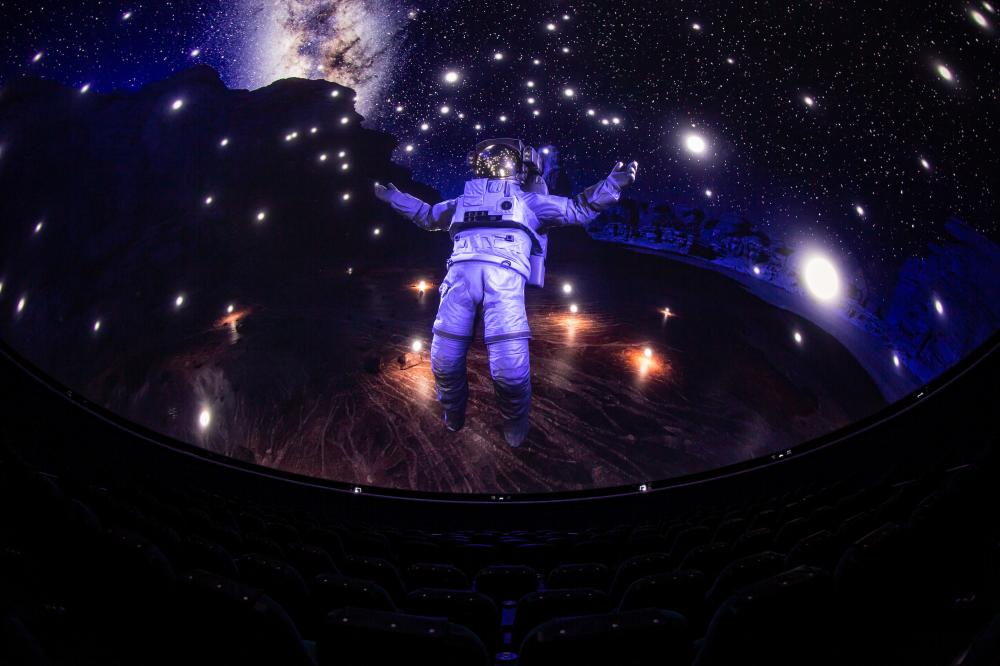 An astronaut is displayed on the screen of the Dome Theater at Exploration Place