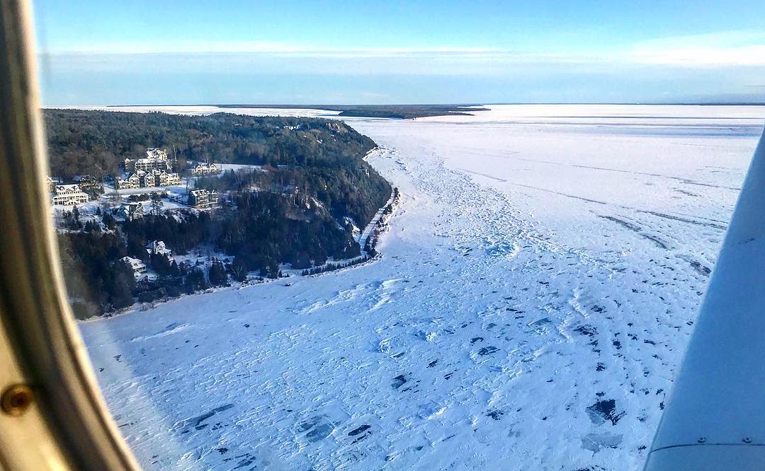 Airplane view of frozen, snowy waters around Michigan’s Mackinac Island