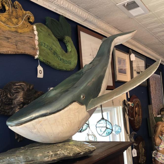 a wooden whale sculpture sits on a  table