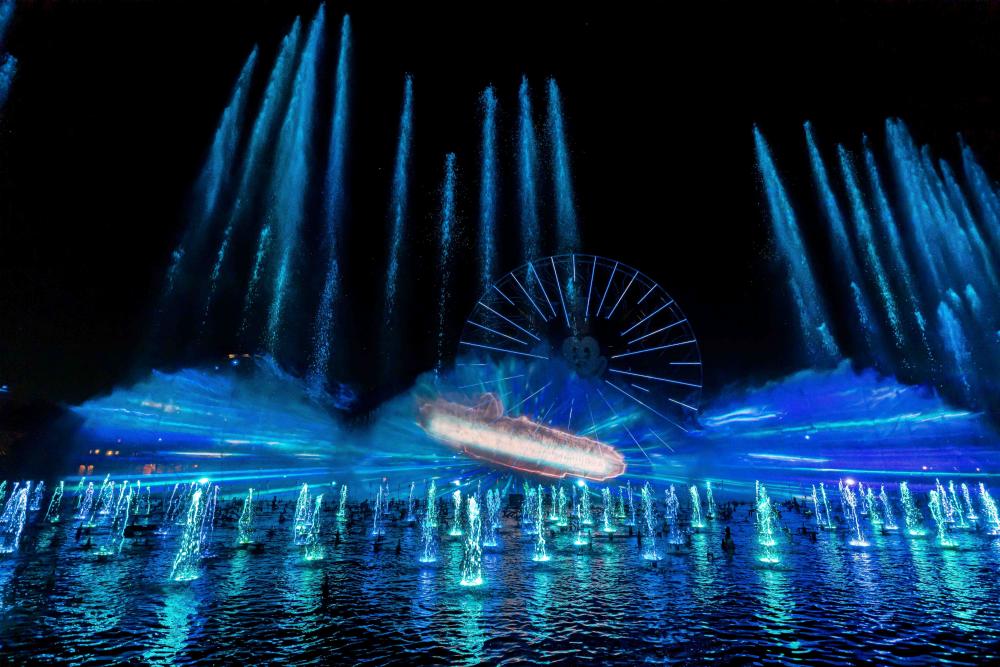 Image of water fountains shooting up towards the sky on a lake. In the mist of the water fountains and image of a space ship from Star Wars can be seen.