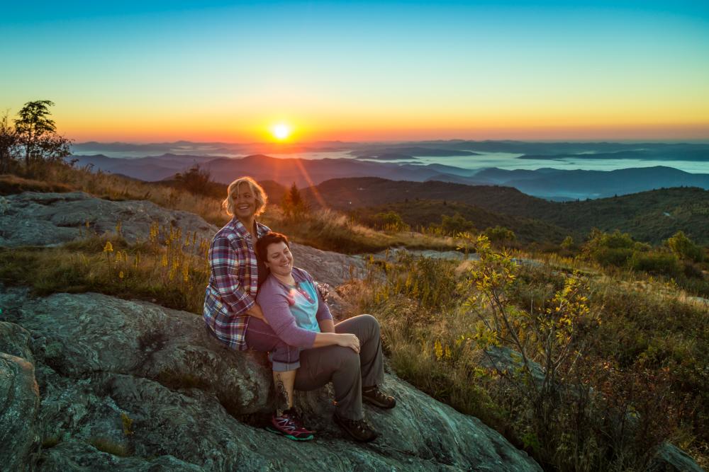 Couple watching sunset on mountaintop