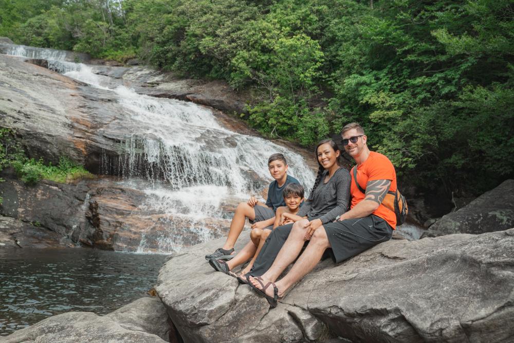 A family enjoys a stunning waterfall in the Blue Ridge Mountains near Asheville, NC