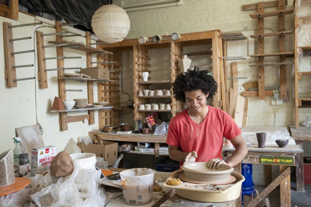 Ceramic artist Tristan Glosby works at the pottery wheel at Clayspace Co-op in the River Arts District of Asheville, North Carolina.