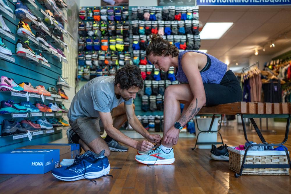 Customer gets fitted for shoes at Jus' Running running store in Asheville