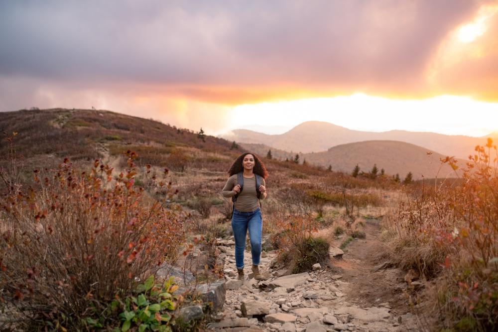 Hiker on top of Black Balsam during sunset with fall colors