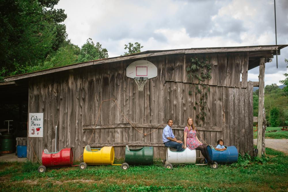 Family posing in front of barn at Hickory Nut Gap Farm