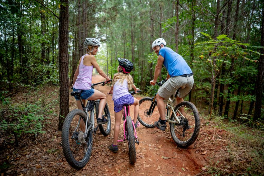 A family mountain biking through the woods near Athens, GA