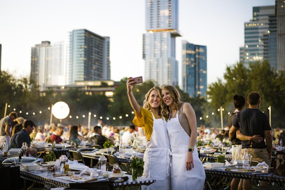 Two women take a selfie in front of skyline at Austin Food and Wine Festival