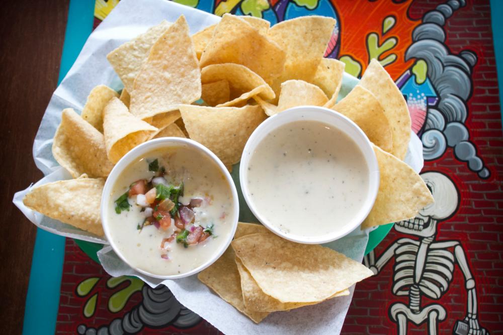 Chips and queso on an indoor table at Tacodeli