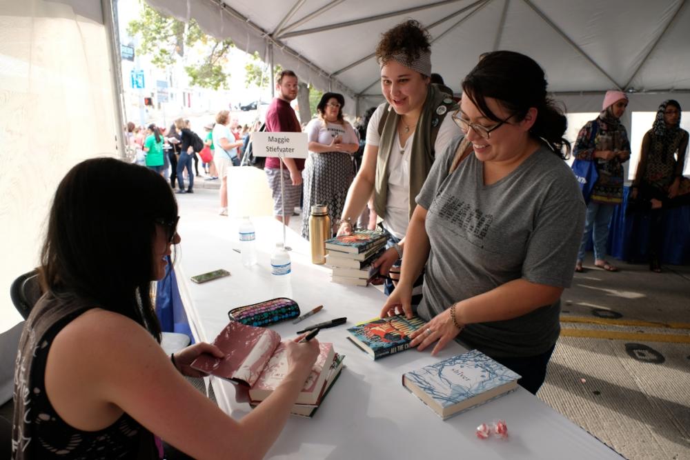 Women getting books signed by author inside tent at Texas Book Festival in austin texas