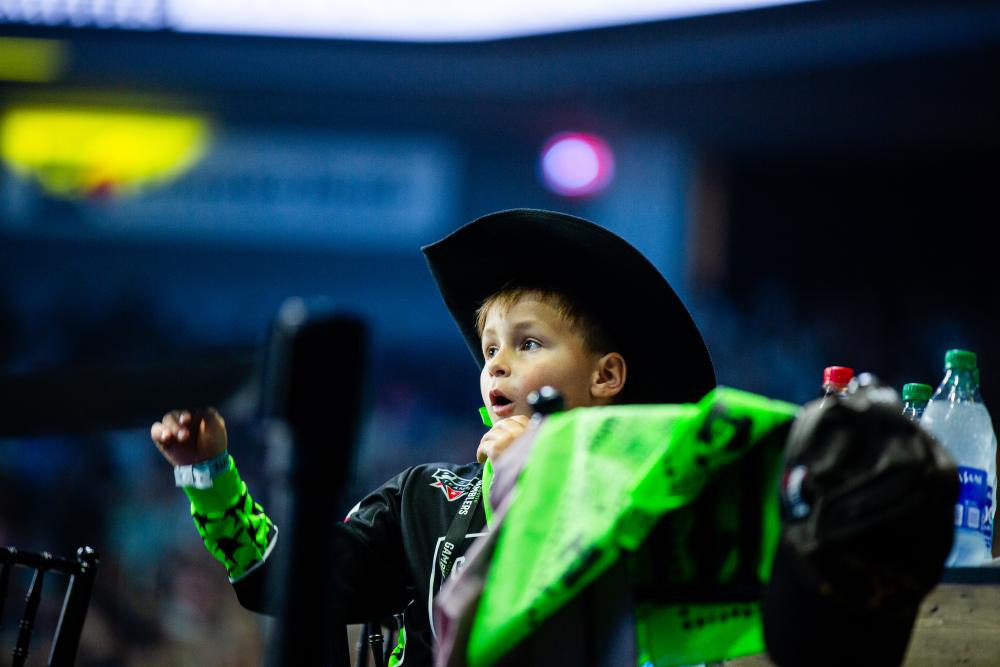 Boy in black cowboy hat and Austin Gamblers jersey cheering on the Austin Gamblers from stadium seat.