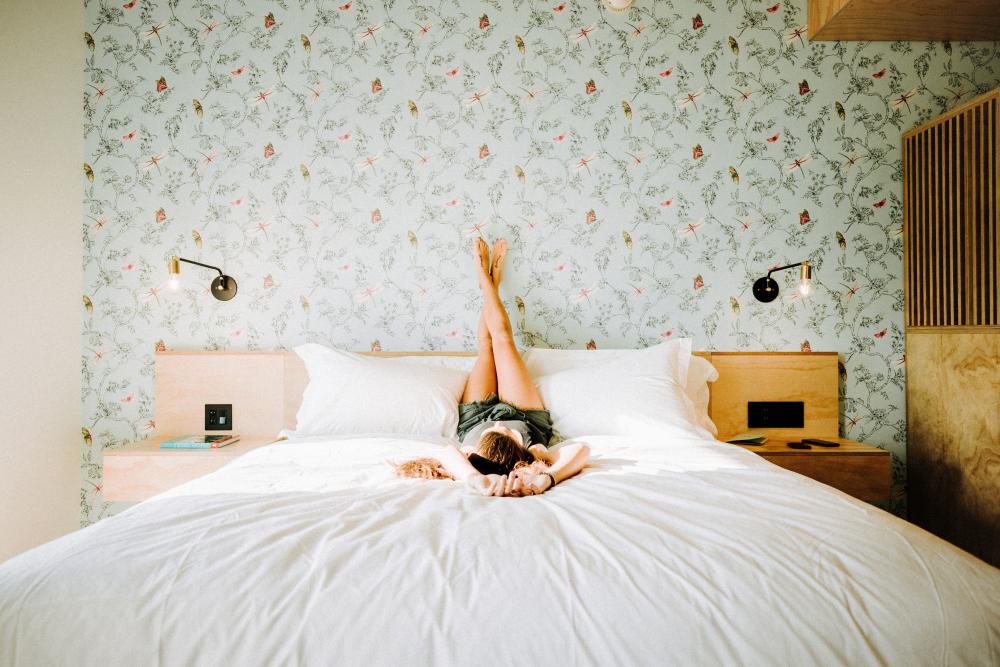 Woman relaxing on bed at Arrive Austin hotel in Austin Texas