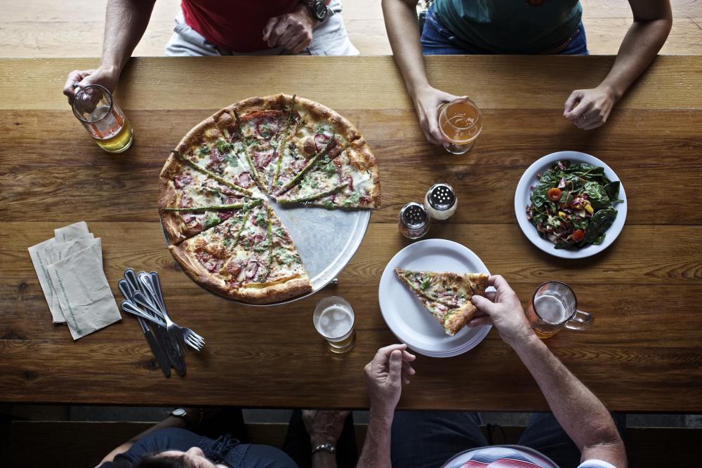 People with pizza and beers at ABGB Austin Beer Garden Brewing Company in Austin Texas