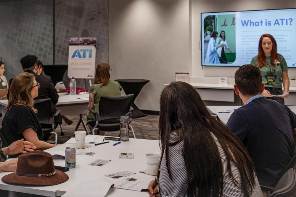 Professionals in a class room setting looking at a presentation.