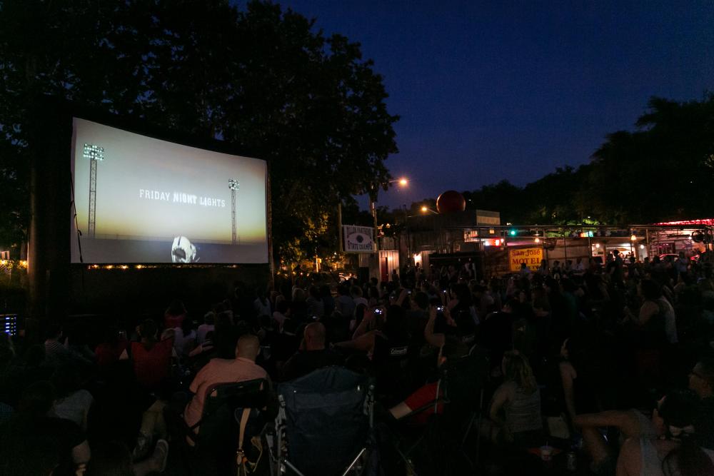 ATX TV Festival attendees on outdoor lawnchairs, watching a screening at a drive in theater.