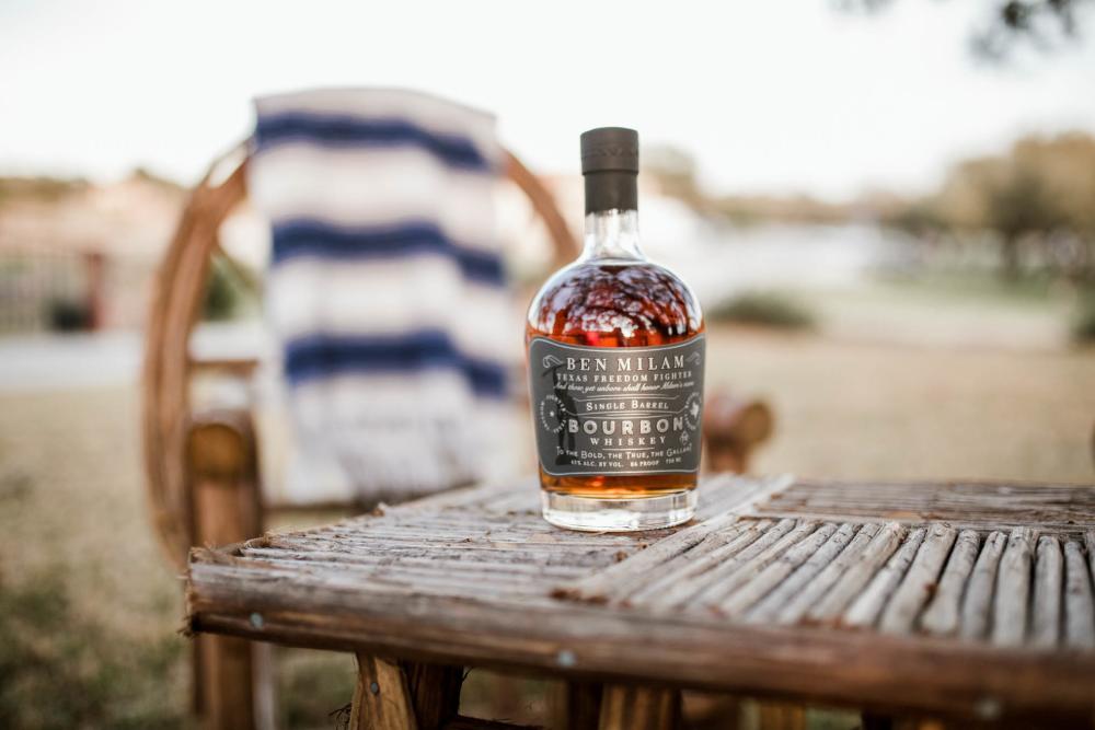 Ben Milam Bourbon bottle on a table outside