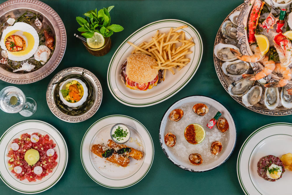 Assortment of plates topped with raw seafood, burgers and fried, caviar and more.