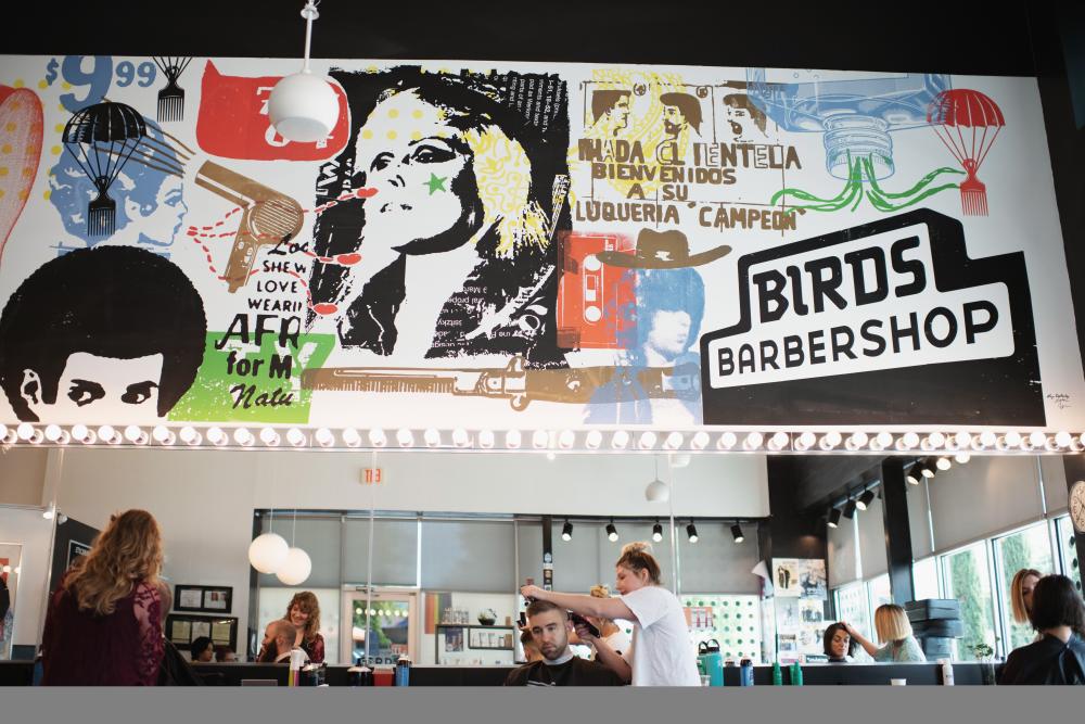 mural on the wall at Birds Barbershop South Lamar above stylists